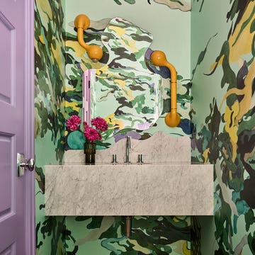 Compact bathroom featuring a camouflage wall design and modern sink.