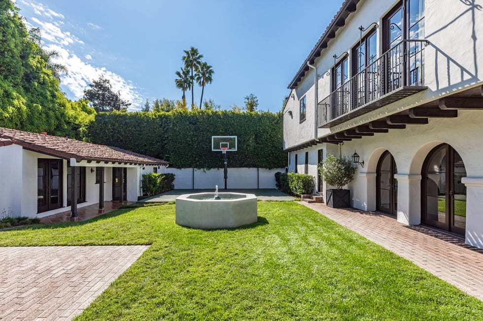 Backyard area featuring a basketball hoop and a fountain.