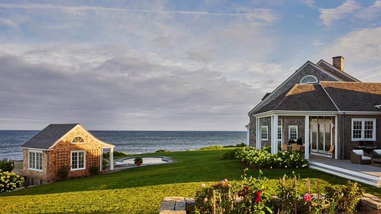 Coastal property featuring a house, a small shed, and a landscaped garden. Coastal property featuring a house, a small shed, and a landscaped garden.