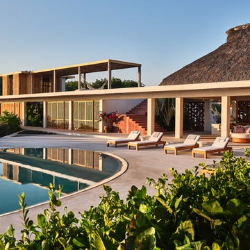 Contemporary villa with a pool surrounded by greenery.