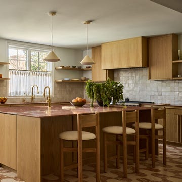 Modern kitchen with wooden cabinetry and marble island.