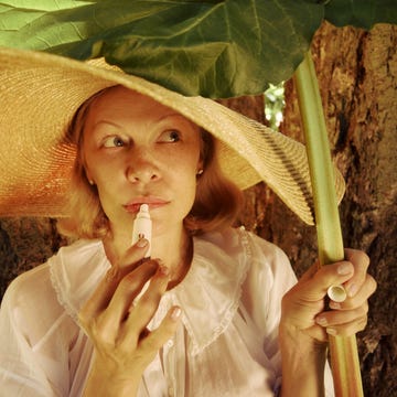 Person holding a large leaf while outdoors.