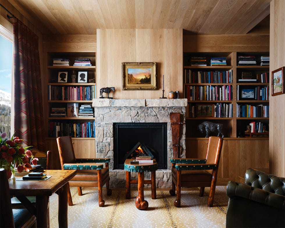 Cozy living room with a fireplace, bookshelves, and rustic furniture.