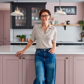 una cocina con isla rosa y armarios grises