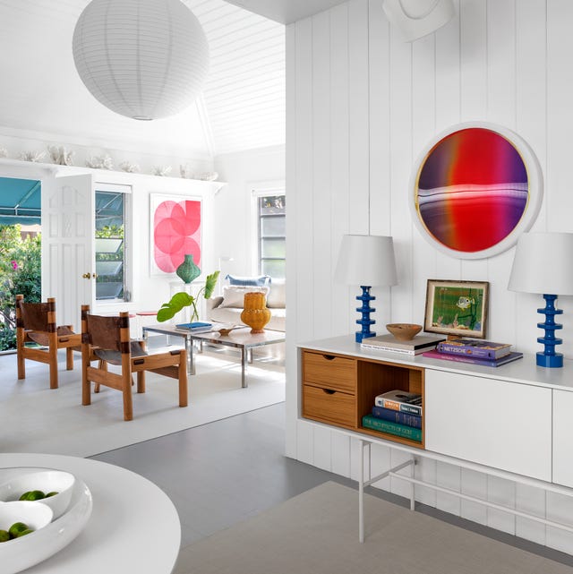 white living area with white console and blue lamps and wood chairs and a glass cocktail table