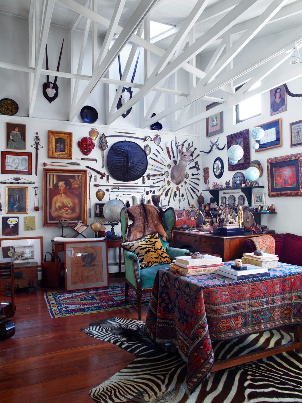 A cluttered and eclectic room filled with various artworks and decorative objects A cluttered and eclectic room filled with various artworks and decorative objects