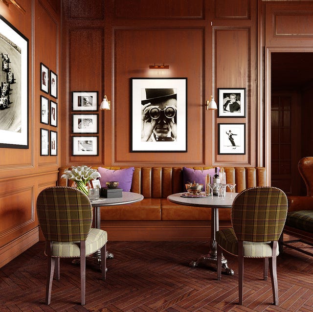 wood paneled dining area with framed photos on the the wall and with a leather banquette and upholstered chairs and two small pedestal table