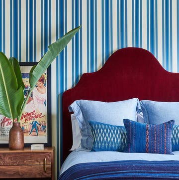 a bed with pillows and linens in indigo hues
