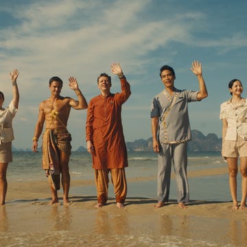 group of people standing on a beach waving their hands group of people standing on a beach waving their hands