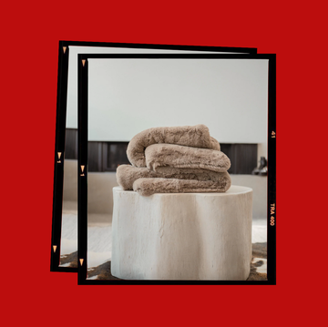 stack of soft fluffy blankets on a wooden side table